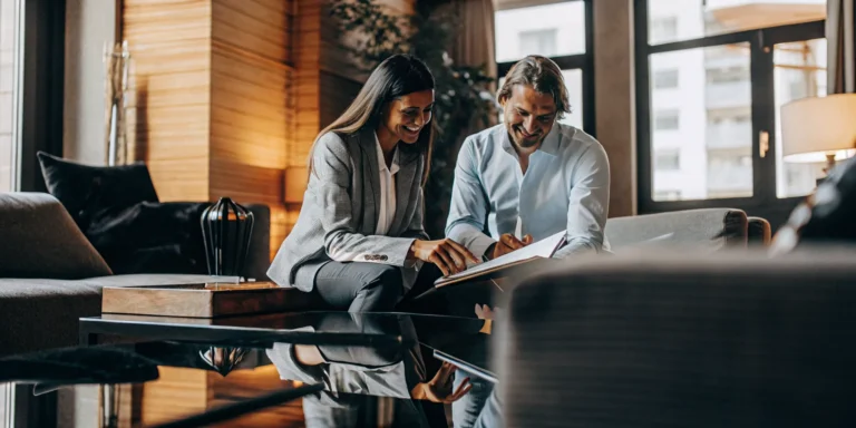 Property manager and owner reviewing contract documents together at a modern apartment building