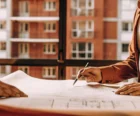 Property owners and managers reviewing financial plans and blueprints around a conference table {{brizy_dc_image_alt entityId=