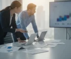 Investors and a property manager reviewing multifamily financial projections and underwriting at an office table {{brizy_dc_image_alt entityId=